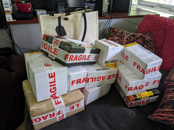 Express Post parcels wrapped in fragile tape on the couch, November 2020